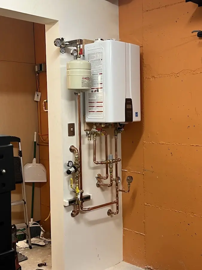 Plumbing technician inspecting water heater connections in Roselle